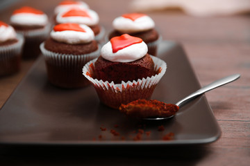 Plate of tasty cupcakes on wooden background