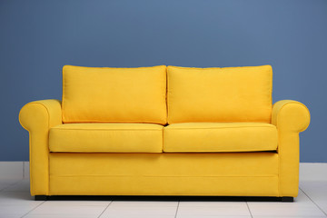 Yellow sofa on a blue wall background