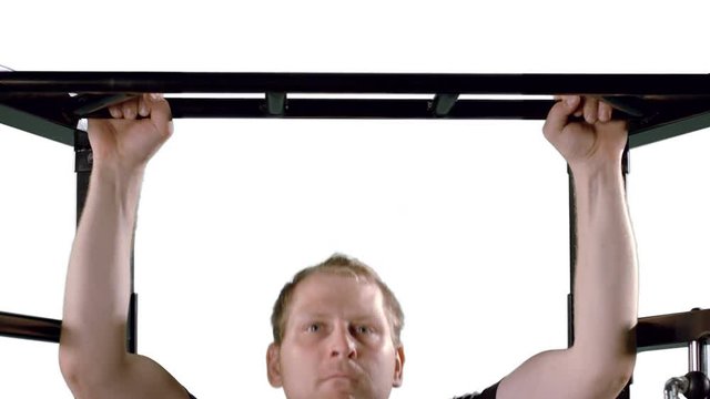 Man working out at the gym, doing pull ups on a frame.  Slow motion, medium close up in ProRes 422 HQ with clean white background, originally recorded in 12-bit 4K RAW at 60fps against green screen.