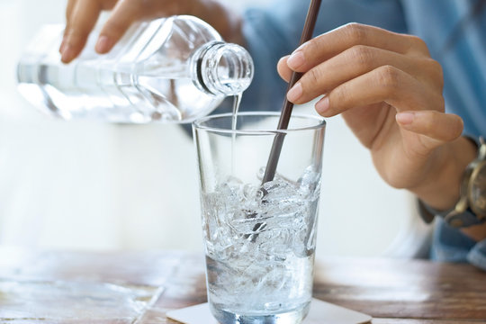 woman drink water with ice in glass on a table in restaurant background