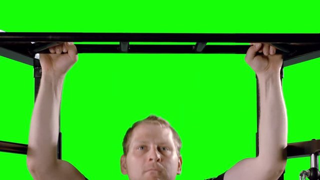 Man working out at the gym, doing pull ups on a frame.  Slow motion, medium close up in ProRes 4444 with clean green background, originally recorded in 12-bit 4K RAW at 60fps against green screen.