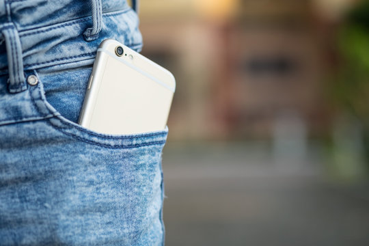Smart phone in pocket of girl's jeans