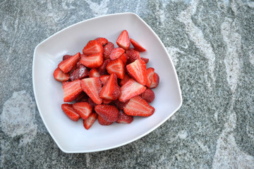 Erdbeeren in weißer Schale auf Granittisch