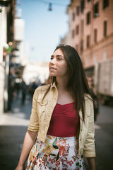 Young pretty woman walking in the city in summer