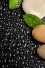 zen stones on black with water drops