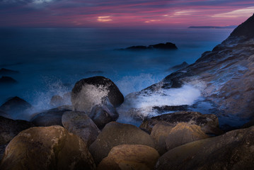 Wave crashing on rocks creates large spray