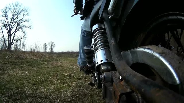 Motorcycle on  dirt rural road, POV view from rear side. Sound


