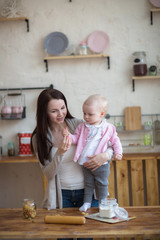 mother with her baby daughter in kitchen together cooking, lifes