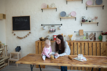 mother with her baby daughter in kitchen together cooking, lifes