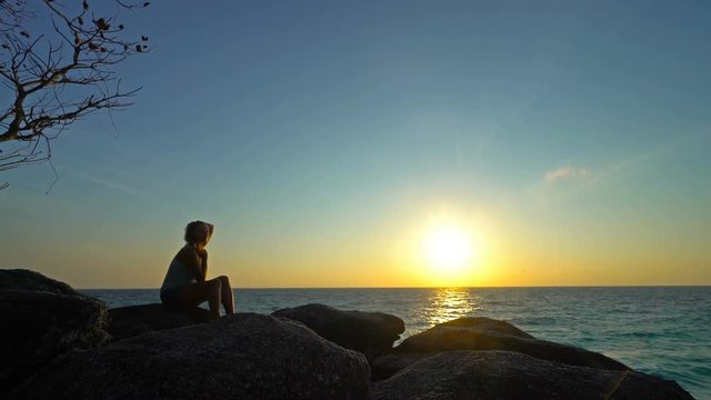 Girl is enjoying a Beautiful sunrise over the tropical sea.