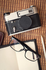 Notebook camera and sunglasses under the window light .