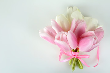 pink and white tulips are associated with pink ribbon on white isolated background