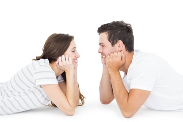 Happy couple lying on the floor looking to each other
