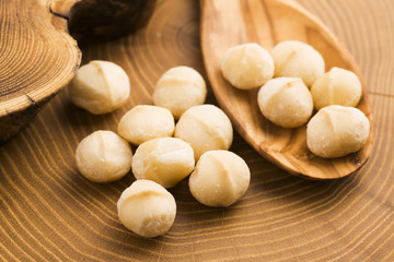 Fototapeta na wymiar Roasted Macadamia nuts on rustic wooden background
