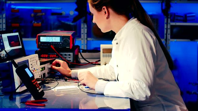 Woman In The Electronics Lab tested electronic device