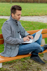 Obraz premium Mann mit Laptop im Park