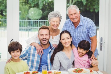 Portrait of smiling multi generation family at dining table 