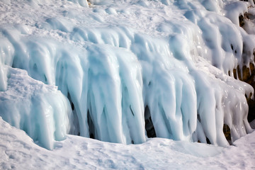 Ice over rocks wall on Baikal lake at winter