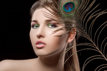 girl with bright  makeup and peacock feathe