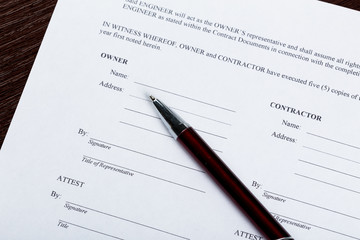 Pen and contract papers on wooden desk