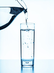 Pour water from a pitcher into a glass