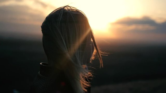 Beautiful girl watching the sunset and smiling, solar flare