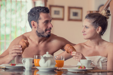Young undressed couple have breakfast in the morning