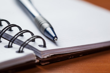 Blank note paper with pen on wood background