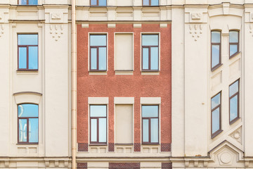 Several windows in row on facade of urban apartment building front view, St. Petersburg, Russia.