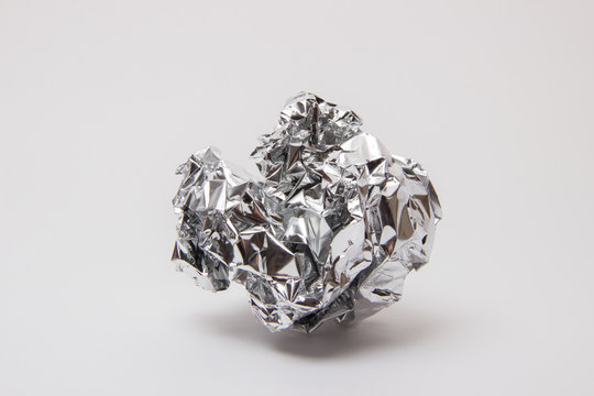 Shiny foil, crumpled into a ball on a white background