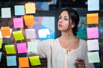 Businesswoman moving a post-it