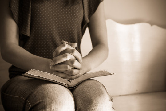 Vintage tone of woman hands on bible. she is reading and praying
