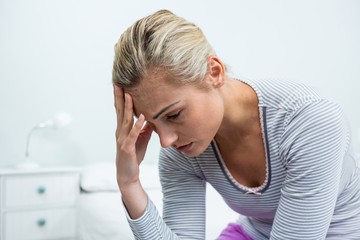 Upset woman with headache at home