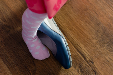dziecko zakłada buty swojej mamy 