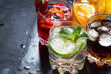 assortment of fresh iced fruit drinks on a black background