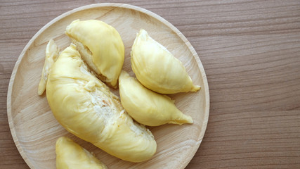 Smelly yellow ripe durian on wood plate. Tropical summer fruit w
