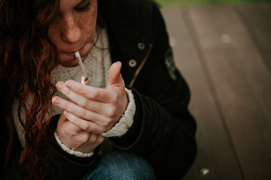 Redhead teen smoking woman in the forest