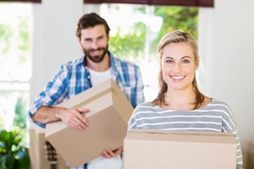 Portrait of young couple holding cardboard boxes