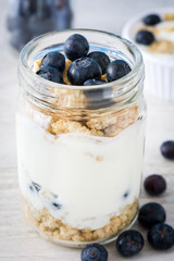 Yogurt with blueberries on white wood

