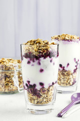 Useful dessert of granola, yogurt and blueberry in glass on a white background