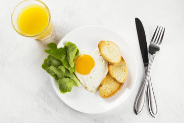 Breakfast: fried eggs with greens, orange juice, coffee on a white background