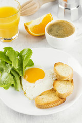 Breakfast: fried eggs with greens, orange juice, coffee on a white background