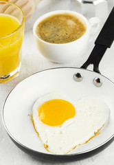 Breakfast: fried eggs in pan, orange juice, coffee on a white background