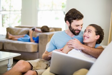 Happy young couple embracing on sofa