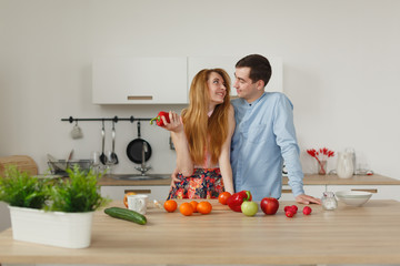 Young couple cooking - man and woman in their kitchen