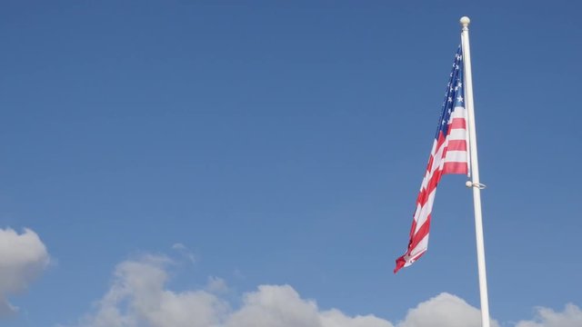 Fabric of American flag against blue sky waving 4K 2160p 30fps UltraHD video - Famous flag of United States of America against blue sky 4K 3840X2160 UHD footage 