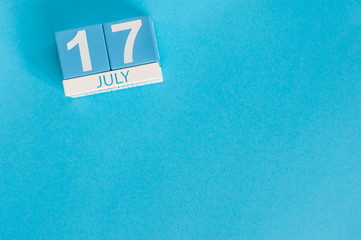 July 17th. Image of july 17 wooden color calendar on blue background. Summer day. Empty space for text
