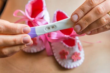 Pregnant woman holding positive pregnancy test