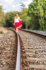 Young lady walking on railway tracks