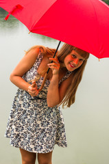 Young lady with red umbrella near the pond